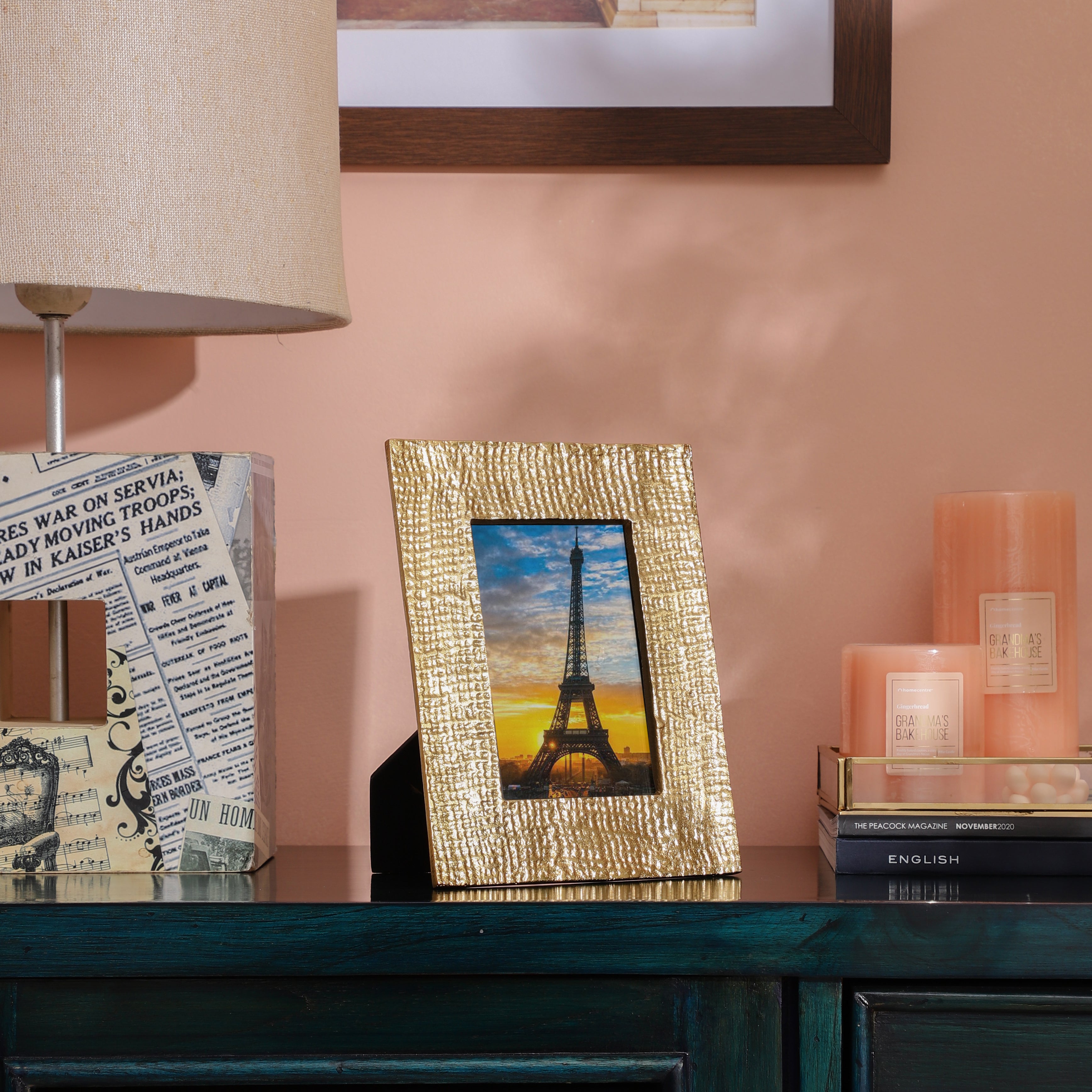 Decorative setup with a gold-framed picture of the Eiffel Tower on a shelf.